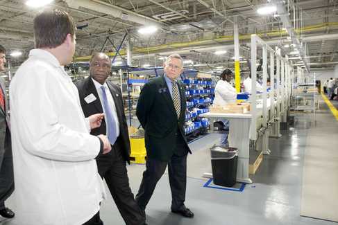 ncrplant Georgia state Sens. Ed Harbison, center, and Seth Harp, right, tour the NCR manufacturing plant following the ribbon cutting ceremony Thursday.